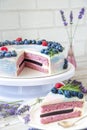 Lavender cake whit berries and flowers on a wooden background. Natiral light, natural colors.