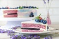 Lavender cake whit berries and flowers on a wooden background. Natiral light, natural colors.