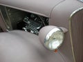 Lavender classic car with headlight and partial grill and engine