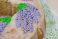 Lavender Cupcake. Sugar coated. Decorated with lavender glaze flowers. A small piece is cut off