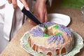 Lavender Cupcake. Sugar coated. Decorated with lavender glaze flowers. A woman cuts a small piece from him