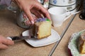 Lavender Cupcake. Sugar coated. Decorated with lavender glaze flowers. A woman cuts a small piece from him