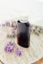Lavender essential oil bottle on white wooden rustic board with fresh lavender flowers. Aromatherapy treatment, natural organic Royalty Free Stock Photo