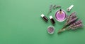 Lavender essential oil glass bottle serum dropper on green color background. Fresh lavender flowers. Aromatherapy treatment.