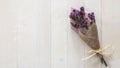 Lavender flower branch bundle dried white wood texture backdrop