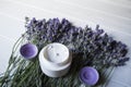 Lavender flowers, candles and cream on a white wooden background. Royalty Free Stock Photo