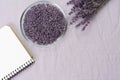 Lavender flowers in glass bowl, notebook for recipes and branches on light background, toned. Invitation, spa, recipe
