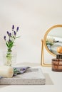 Lavender flowers inside a glass vase on a gray tray with candles and towels, and a diffuser of essential oils is placed next to a Royalty Free Stock Photo