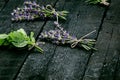 Lavender flowers, rosemary, mint, thyme, melissa with old scissors on a black wooden table. Burnt wood. Spa and cosmetic or cookin Royalty Free Stock Photo