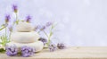 Lavender flowers and stones on wood over abstract lilac background