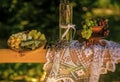 Lavender flowers in vase, grapes and cheese on white tablecloth