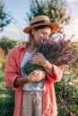 Lavender harvest. Farmer holding bundle of cut herb. Woman smelling picked bouquet of purple flowers in summer garden Royalty Free Stock Photo