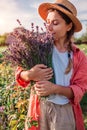 Lavender harvest. Farmer holding bundle of cut herb. Woman smelling picked bouquet of purple flowers in summer garden Royalty Free Stock Photo