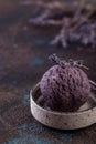 Lavender ice-cream in round grey plate on brown background