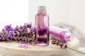 Lavender liquid. Bath cosmetics products in bottles on white wooden rustic board, fresh lavender flowers, soap, bath beads. Royalty Free Stock Photo