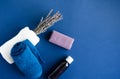 Lavender, oil and lavender soap on a blue background. Dry lavender wrapped in a white towel. Nearby lies a blue towel.