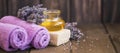 Lavender oil, towels, natural soap on wooden background, lavender spa still life setting Royalty Free Stock Photo