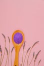 lavender salt in wooden spoon and lavender flowers on a pink background.purple sea bath salt . Flower bath salt