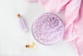 Lavender spa setting: salt, essential oil and dried flowers natural spa products and decor for bath on light background