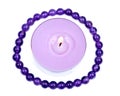 Lavender tea light candle surrounded by royal purple amethyst bead bracelet
