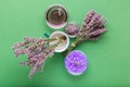 Lavender violet sea salt with fresh and dry lavender flowers, essential oil liquid on green color background. Aromatherapy Royalty Free Stock Photo