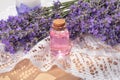 Lavender water in a bottle, a bouquet of fresh lavender on a table with lace