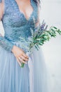 Lavender Wedding bouquet in hands of the bride in white-blue dre