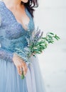 Lavender Wedding bouquet in hands of the bride in white-blue dre