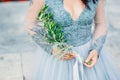 Lavender Wedding bouquet in hands of the bride in white-blue dre