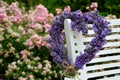 Lavender wreath in the shape of a heart on a white chair in the garden. Royalty Free Stock Photo