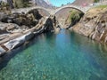 Tourists visiting the famous roman bridge of Lavertezzo on Verzasca valley on the italian part of Switzerland Royalty Free Stock Photo