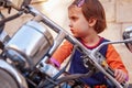 Law for child drivers under 18 concept. Portrait of cute little biker child girl sitting on a motorcycle Royalty Free Stock Photo