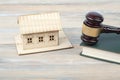 Law concept . Model house with wooden judge gavel on table in a courtroom or enforcement office.