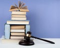 Law concept open book with wooden judges gavel on table in a courtroom or law enforcement office, blue background. Copy space for Royalty Free Stock Photo