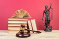 Law concept - Open law book, Judge\'s gavel, scales, Themis statue on table in a courtroom or law enforcement office Royalty Free Stock Photo