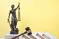 Law concept - Open law book, Judge's gavel, scales, Themis statue on table in a courtroom or law enforcement office. Royalty Free Stock Photo
