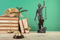 Law concept - Open law book, Judge's gavel, scales, Themis statue on table in a courtroom or law enforcement office Royalty Free Stock Photo