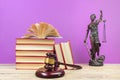 Law concept - Open law book, Judge's gavel, scales, Themis statue on table in a courtroom or law enforcement office Royalty Free Stock Photo