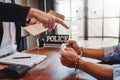 Law enforcement officer interrogating Criminals male with handcuffs in the investigation room Police officer interviewing after Royalty Free Stock Photo