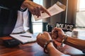 Law enforcement officer interrogating Criminals male with handcuffs in the investigation room Police officer interviewing after Royalty Free Stock Photo