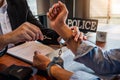 Law enforcement officer interrogating Criminals male with handcuffs in the investigation room Police officer interviewing after Royalty Free Stock Photo