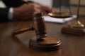 Law and justice. Closeup of judge working at wooden table, focus on gavel Royalty Free Stock Photo