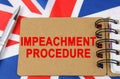 Against the background of the flag of Great Britain lies a notebook with the inscription - IMPEACHMENT PROCEDURE