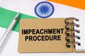 Against the background of the flag of India lies a notebook with the inscription - IMPEACHMENT PROCEDURE