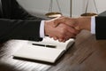 Law and justice. Notary with client shaking hands at wooden table, closeup Royalty Free Stock Photo