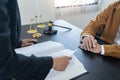 Law,libra scale and hammer on the table, 2 lawyers are discussing about contract paper, law matters determination, holding pen and