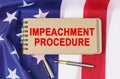 Against the background of the flag of the USA lies a notebook with the inscription - IMPEACHMENT PROCEDURE