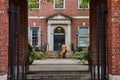 Law student walking through courtyard from brick arches in New York City straight on