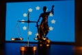 Law symbols. Statue of lady justice and scales on a table against an European flag Royalty Free Stock Photo