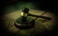 Law theme, mallet of the judge on wooden desk. Law gavel on dark foggy background with light Royalty Free Stock Photo